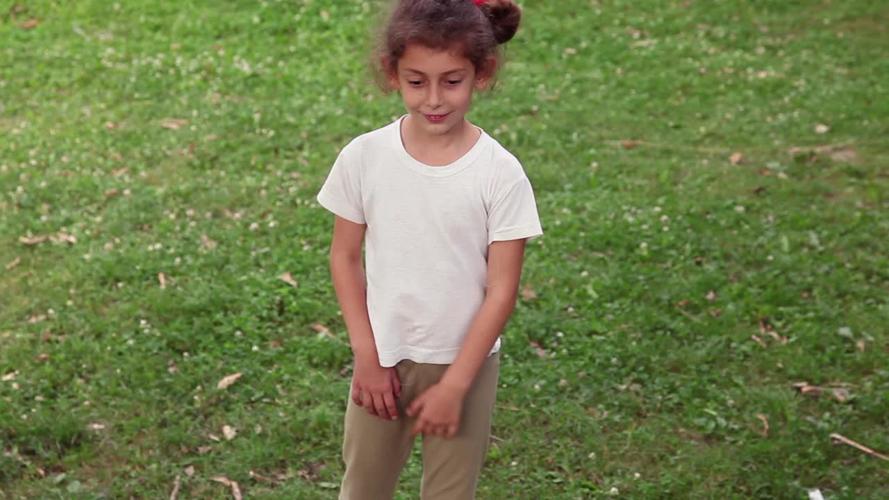一个小女孩在后院从t恤上扯线视频下载