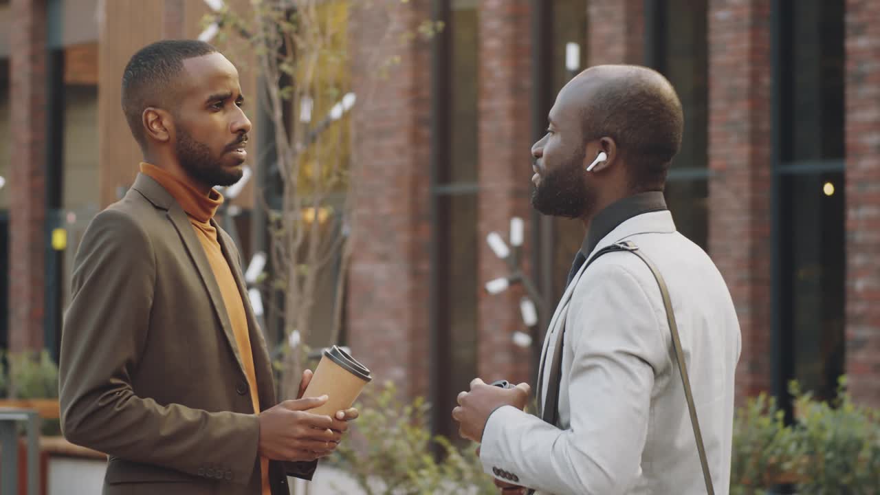 两个黑人商人在街上拿着咖啡聊天视频素材