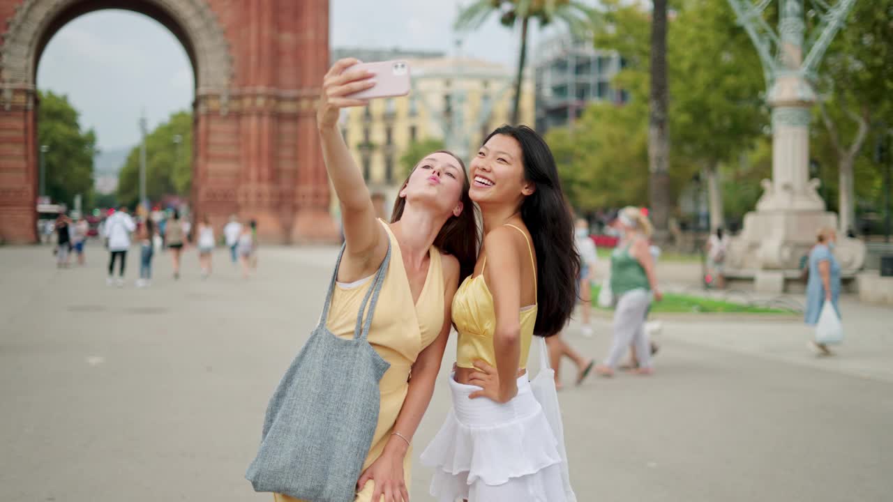 两名女性朋友面带微笑，看着智能手机屏幕自拍视频素材