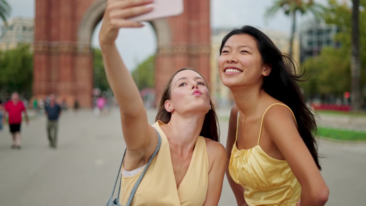 两个快乐的混血女性朋友在户外自拍，并选择最好的照片在手机上视频素材