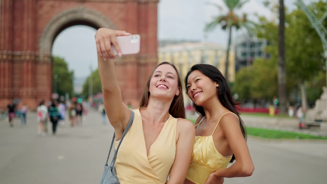 微笑的多种族女友游客在城市历史建筑前摆出自拍照片视频素材