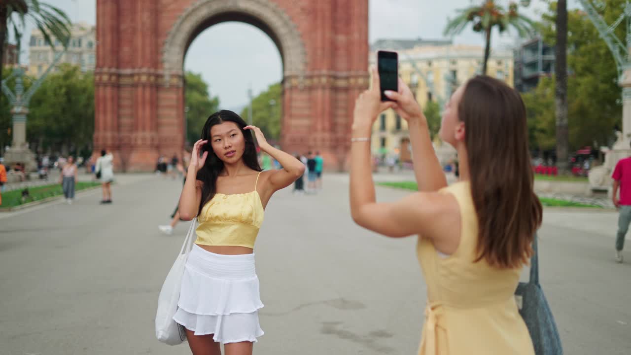一个女人在户外用手机拍摄她最好的亚裔女性朋友视频素材