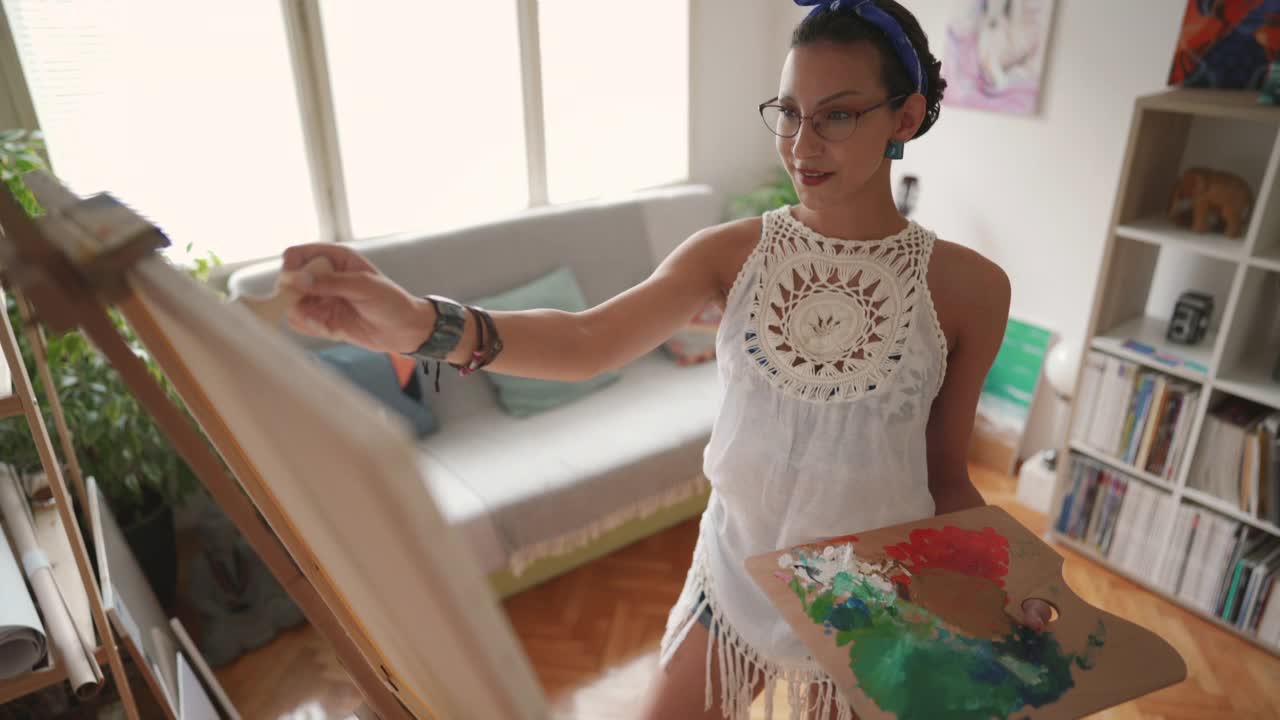专注专注的女性艺术家在画布上作画视频下载