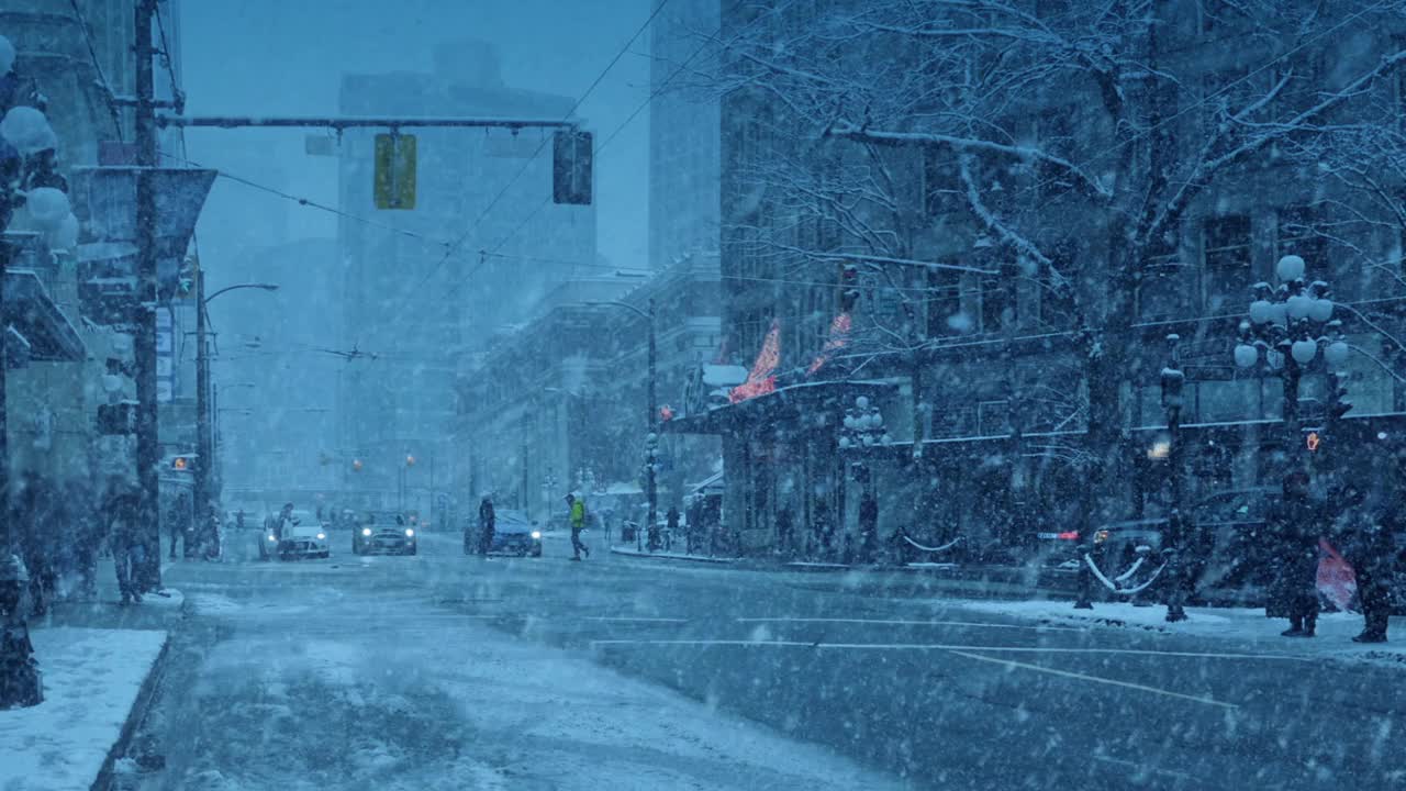 在暴风雪中的城市，汽车和人在晚上视频素材