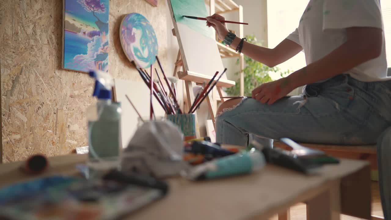 在At工作室，一位陌生的女艺术家在画布上作画视频下载