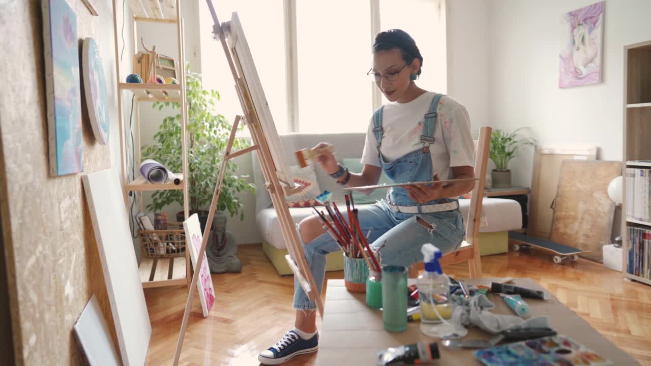 年轻的女画家在画布上作画视频下载