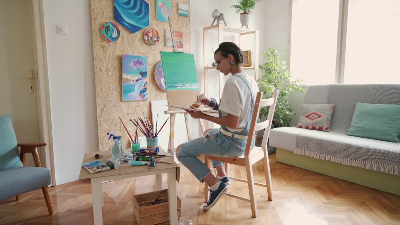 才华横溢的女艺术家享受创作的时间，在画布上作画，在家里视频下载