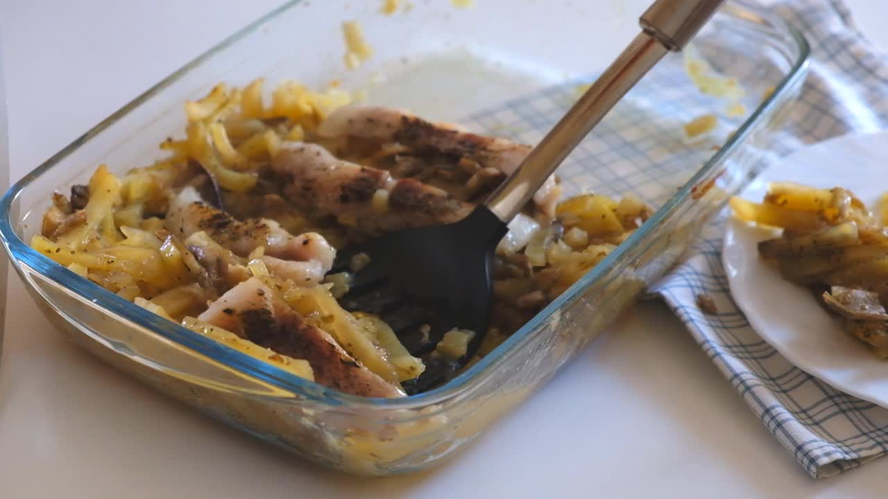 一个女人用铲子把食物放在盘子里。视频素材