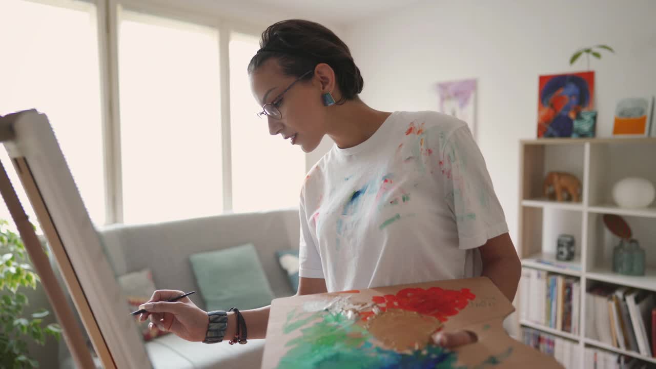 为了提高自己的绘画技巧，年轻女艺术家兢兢业业，同时在一门新的艺术上尝试新的绘画技巧视频下载
