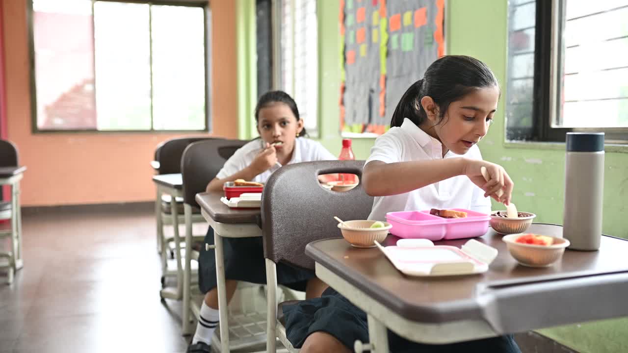 女学生在午休时间在教室里吃东西视频素材