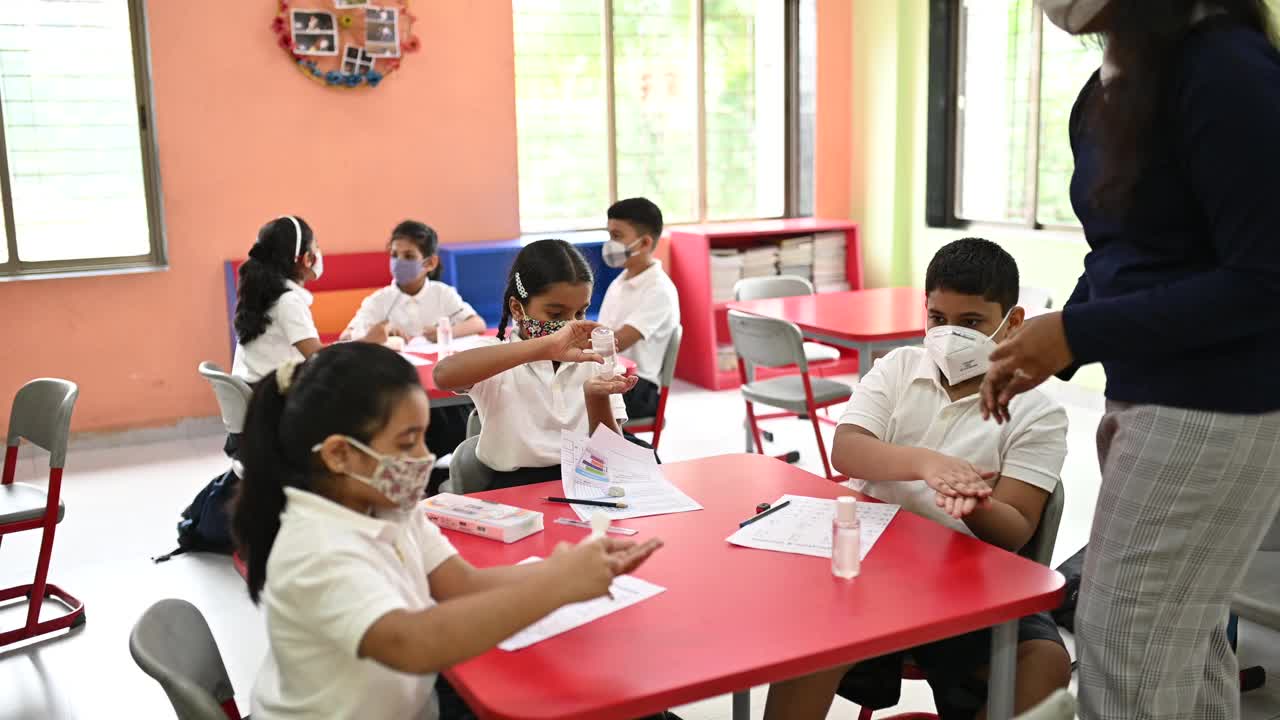 学校老师和孩子们戴着防护口罩洗手视频下载