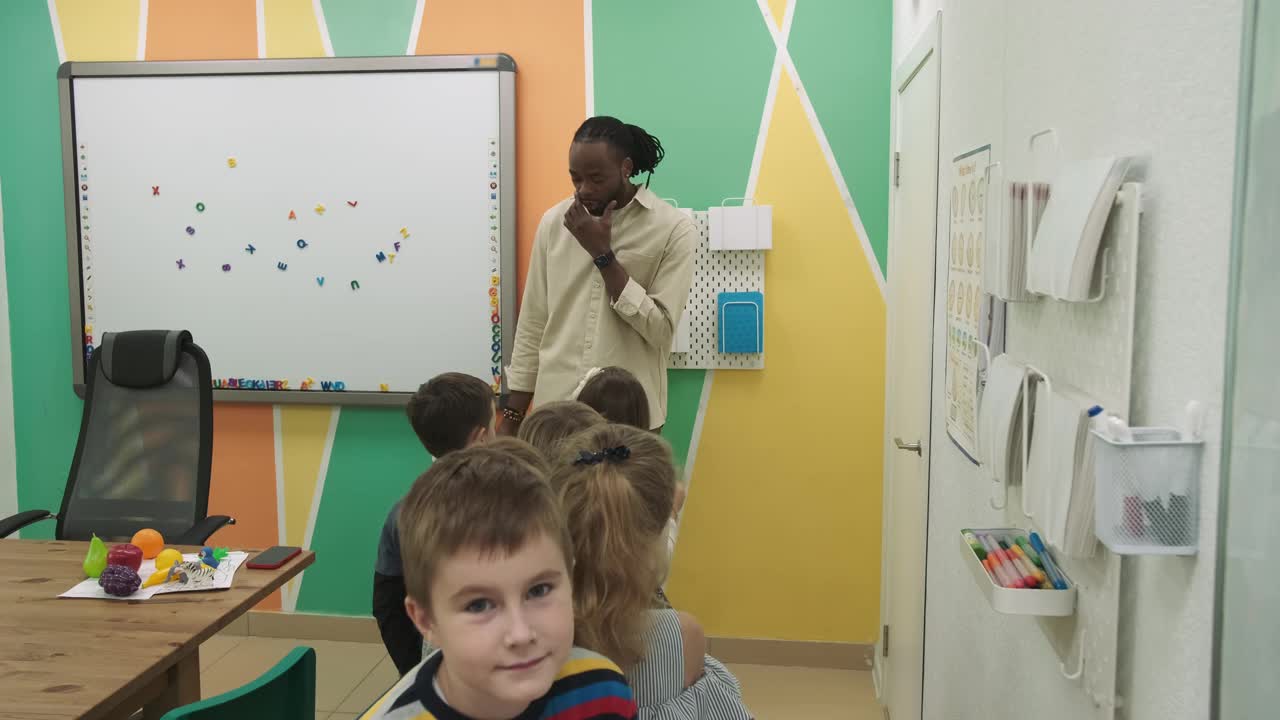 一位非洲裔美国教师教一群10-12岁的孩子学习动物和水果视频下载
