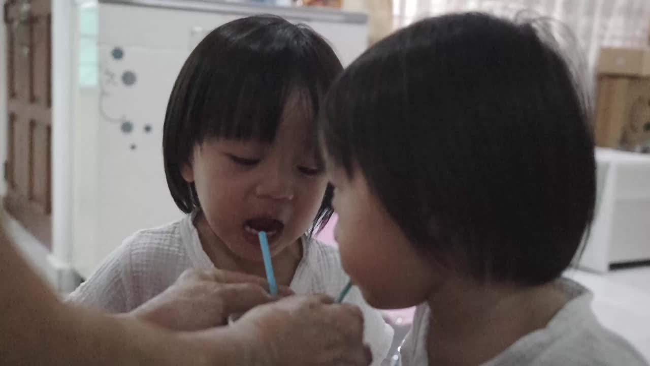 亚洲华人奶奶在家里用吸管喂双胞胎男婴视频下载