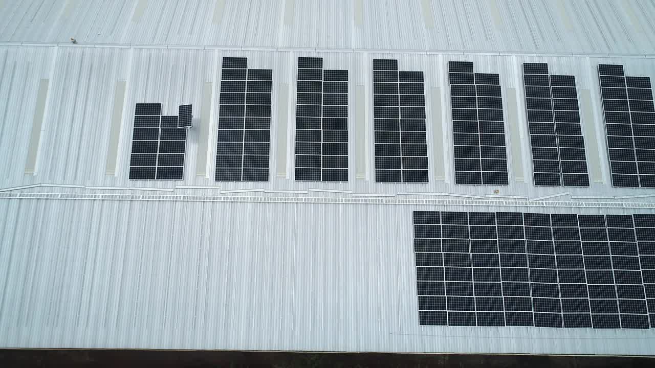 技术人员在屋顶安装太阳能电池板的Arial视图。视频素材