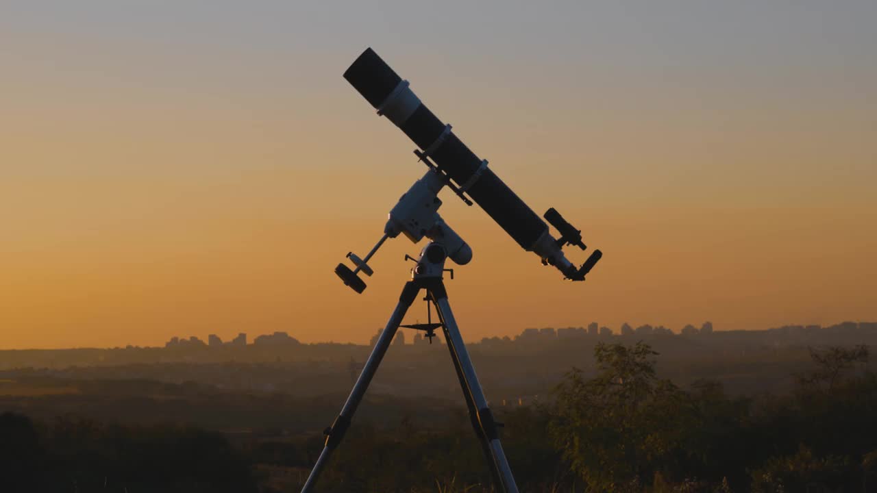 望远镜的轮廓和遥远的城市地平线。视频下载