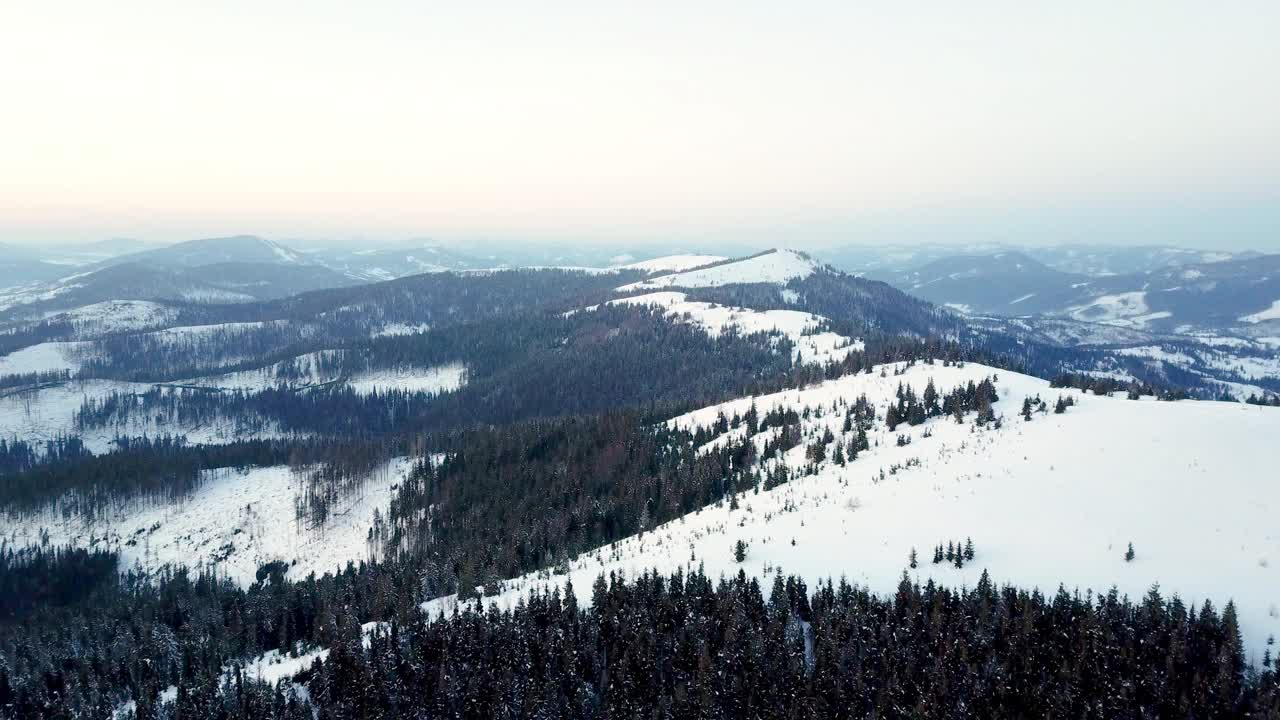 从童话般的高山景观上看，白雪覆盖着阿尔卑斯的尖峰。乌克兰喀尔巴阡山脉的寒冬。厚厚的白云。开放空间。空中4 k视频素材
