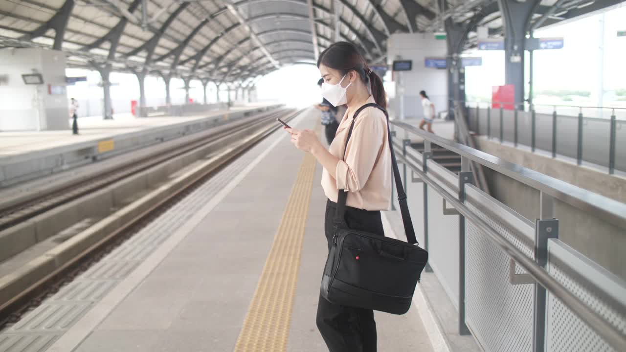 一名女子在曼谷火车站用智能手机等车视频素材