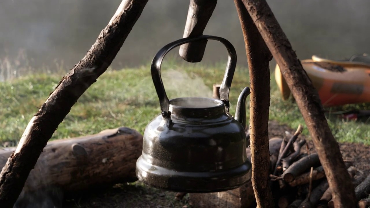 早晨篝火上的古董茶壶。视频下载