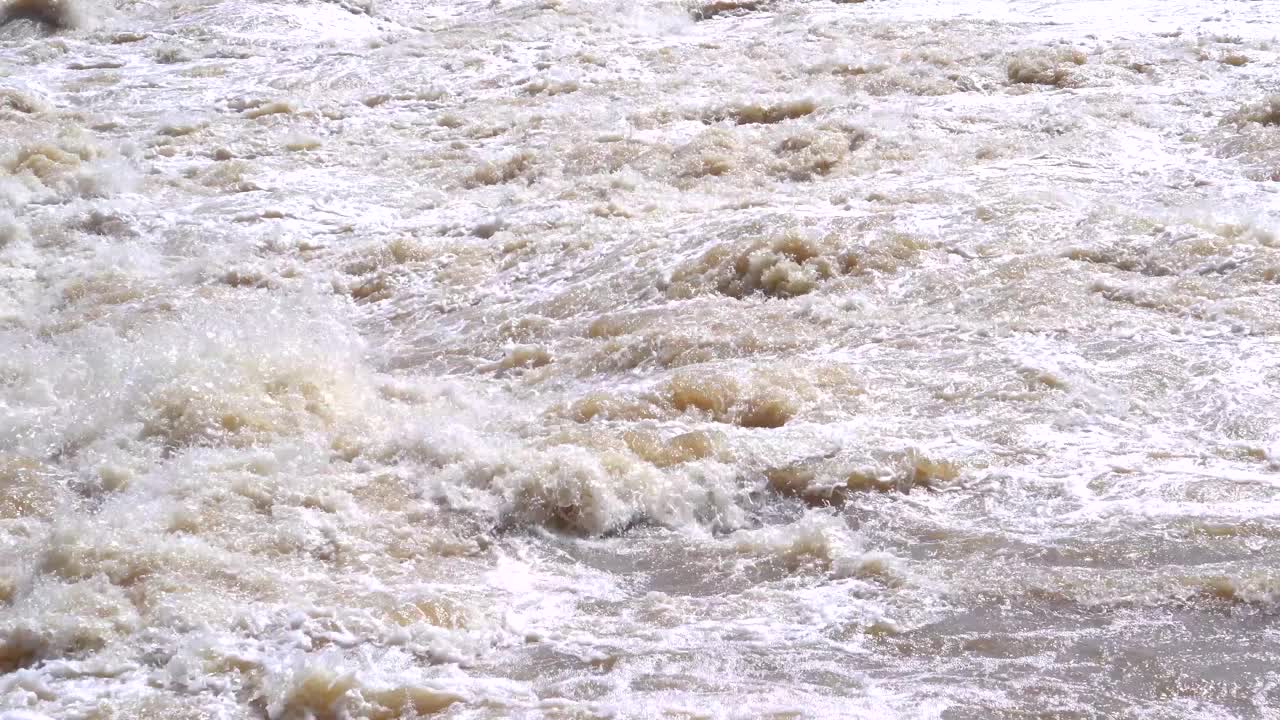 水从坝门释放出来，由高速水流入河中视频下载
