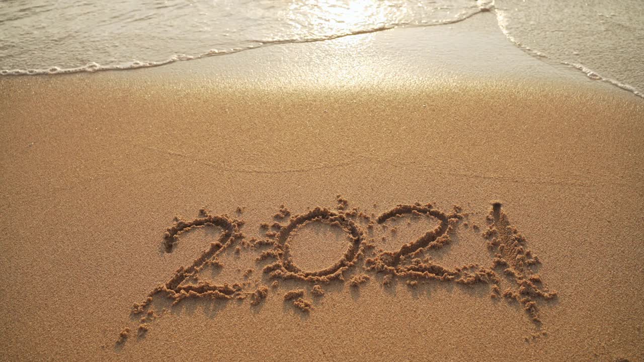 2021年再见。在沙滩海浪沙滩上，祝2022年新年快乐视频下载