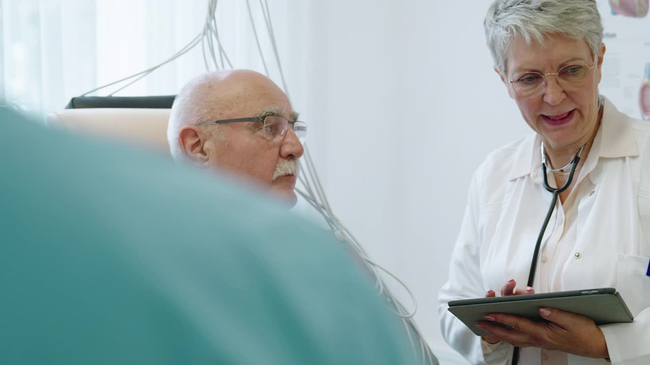 心内科医生使用电子平板电脑与一位老年患者进行心电周期通话视频下载