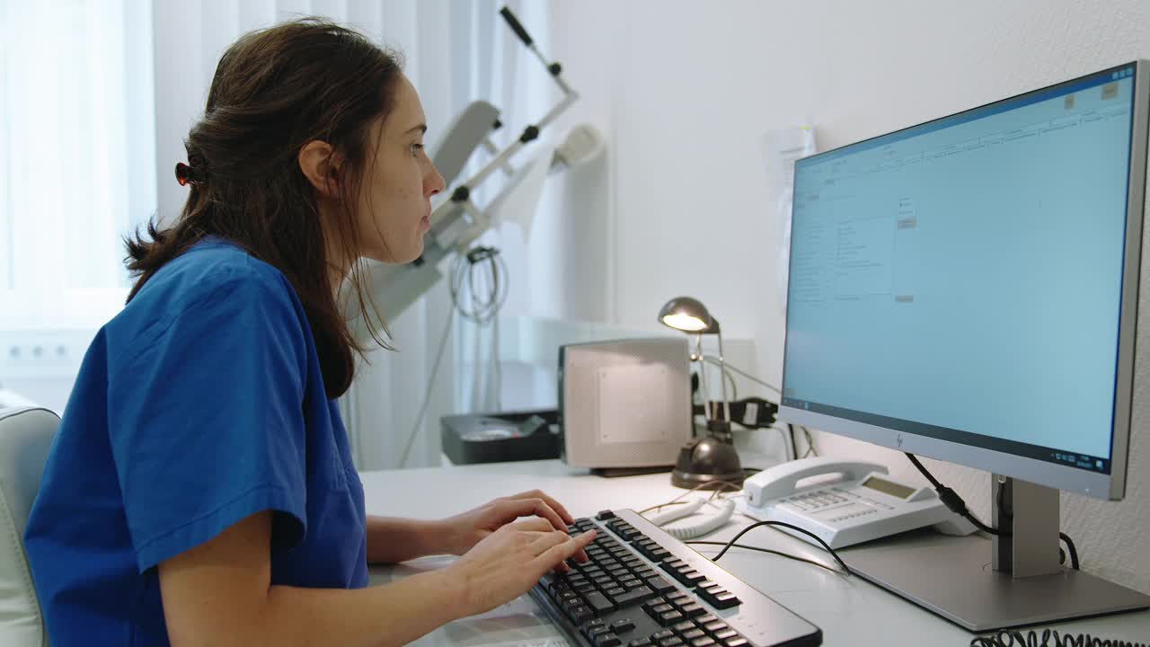 在诊所里用电脑工作的女护士视频素材
