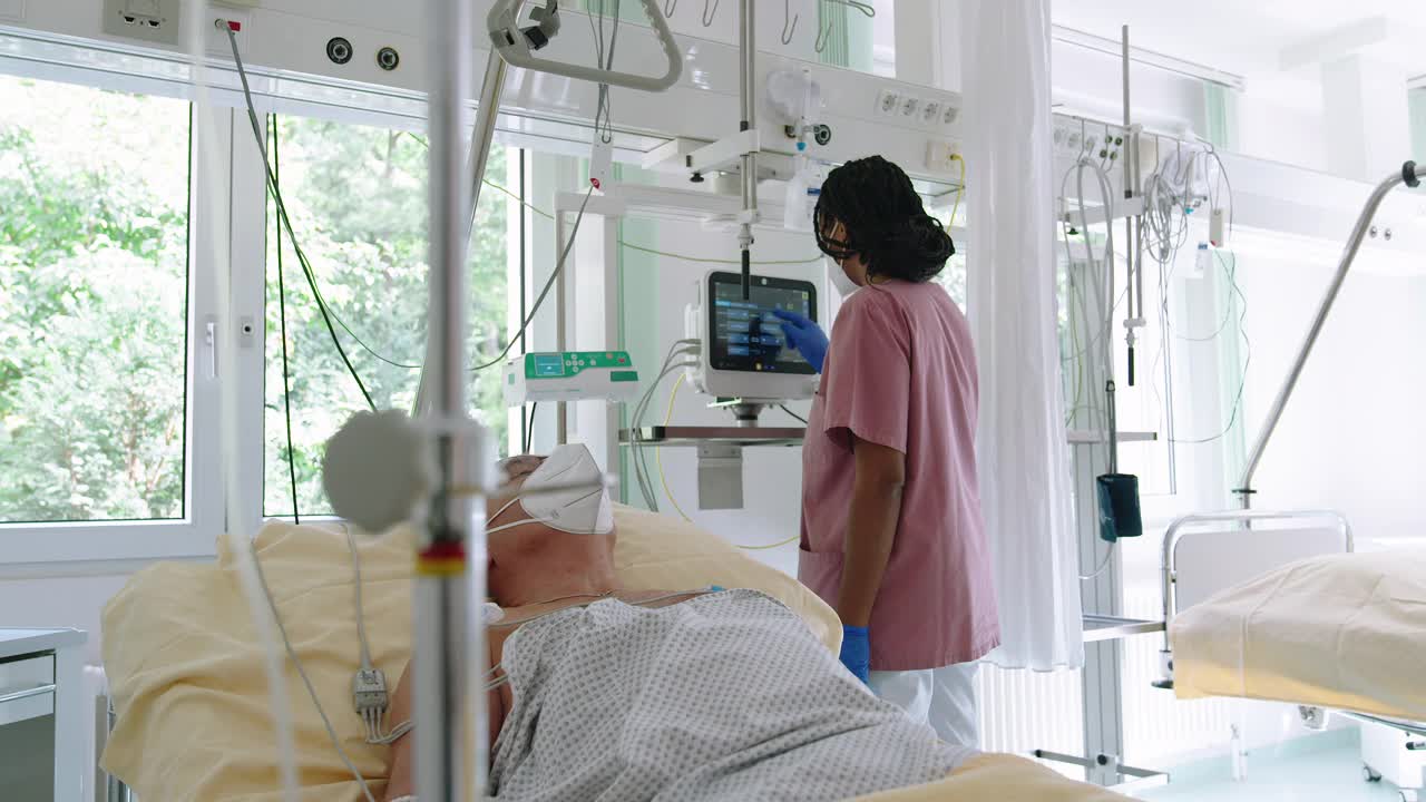 在重症监护病房，护士看着老年病人的生命体征监视器视频下载