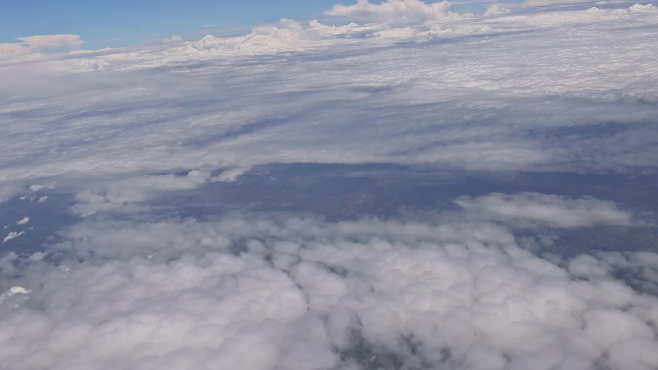 从飞机窗口俯瞰蓝天的高空云朵视频素材