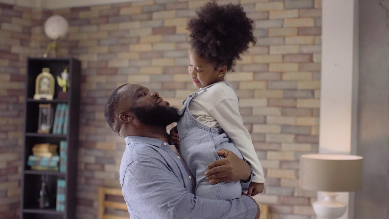 千禧年的黑人父亲和他的女儿在家里玩耍和拥抱，特写镜头视频素材