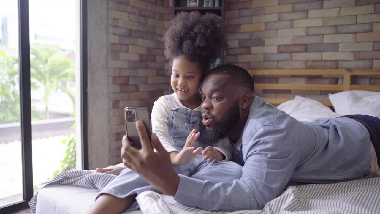 非洲黑人家庭在玩手机和视频通话的同时，享受在一起的时光视频素材