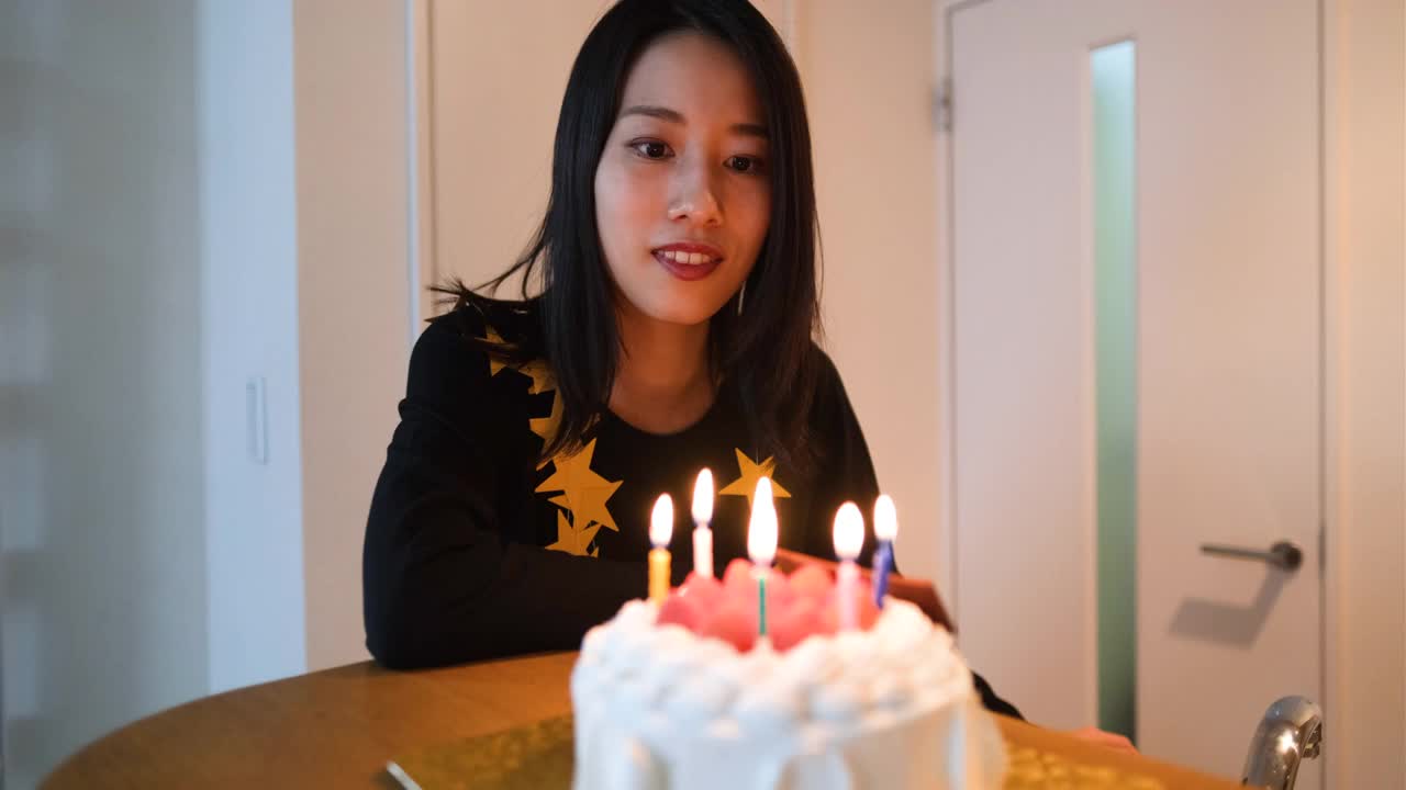 在蛋糕上吹生日蜡烛的女人视频下载