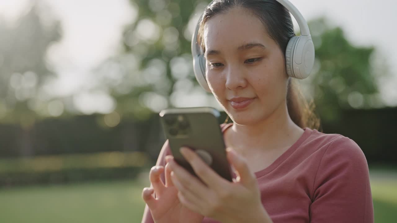 年轻的亚洲女子在日落时一边听音乐一边跳舞视频下载