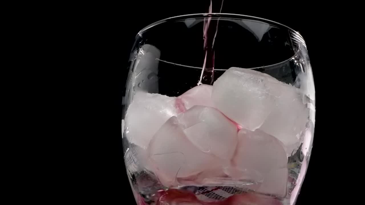 玛格丽塔鸡尾酒黑色背景，倒一杯酒精饮料红色。樱桃汁，加冰，黑色背景红色果汁视频素材