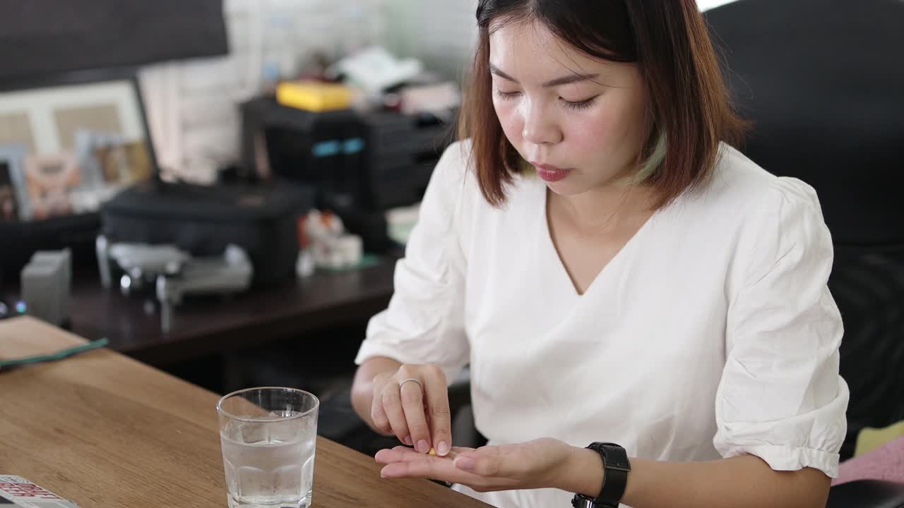年轻的亚洲妇女在生病时服用药物视频下载