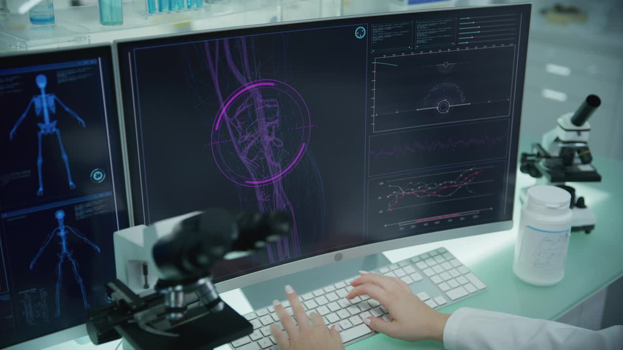 实验室配备电脑和显微镜。带有动画人体模型的屏幕。科学家扫描虚拟病人的损伤。肘部有红色标记。近距离接触视频素材