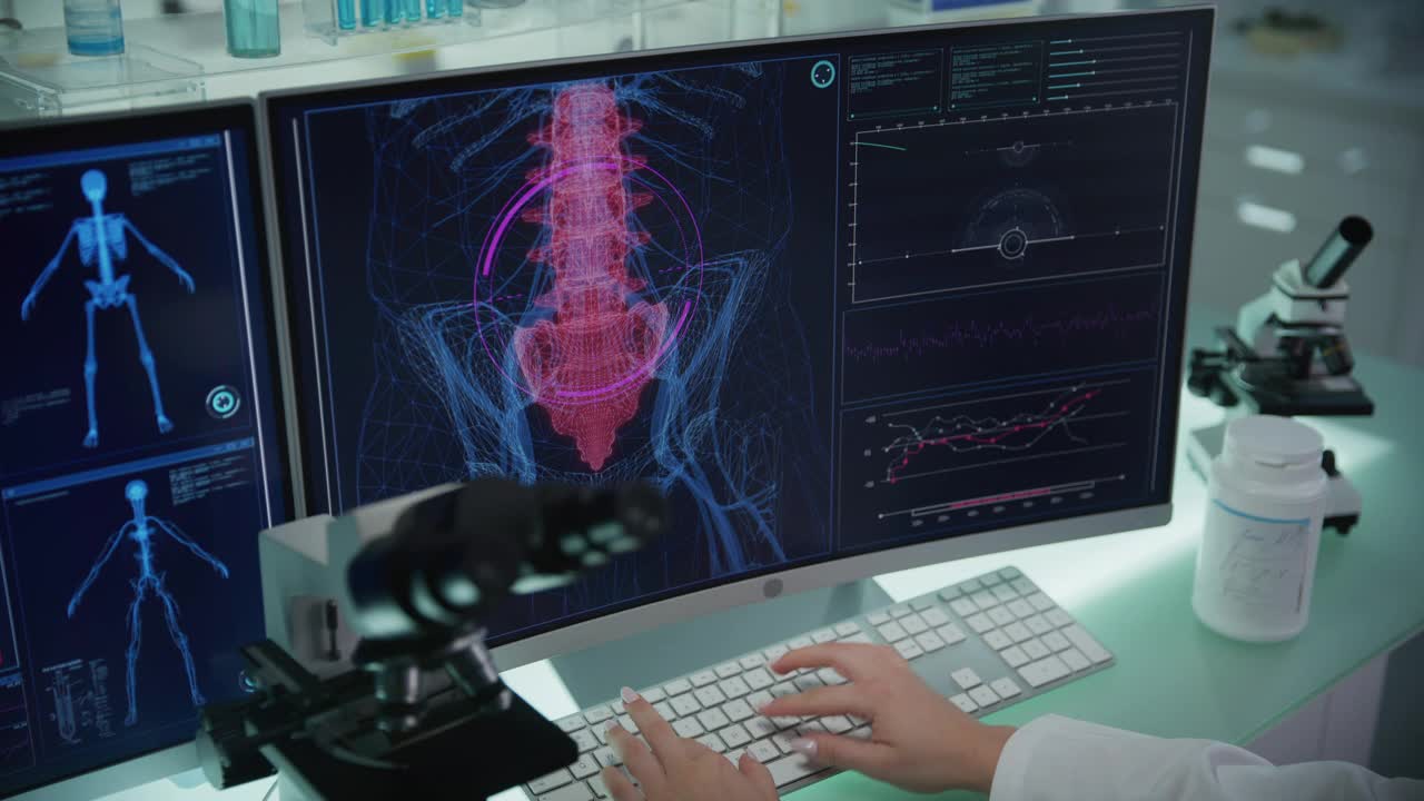 实验室配备电脑和显微镜。带有动画人体模型的屏幕。科学家扫描虚拟病人的损伤。脊柱下部有红色斑纹。近距离接触视频素材