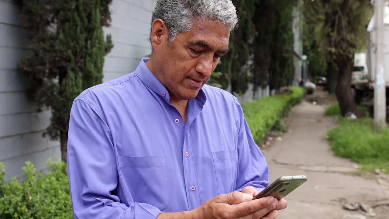 墨西哥男子在户外使用手机。视频素材
