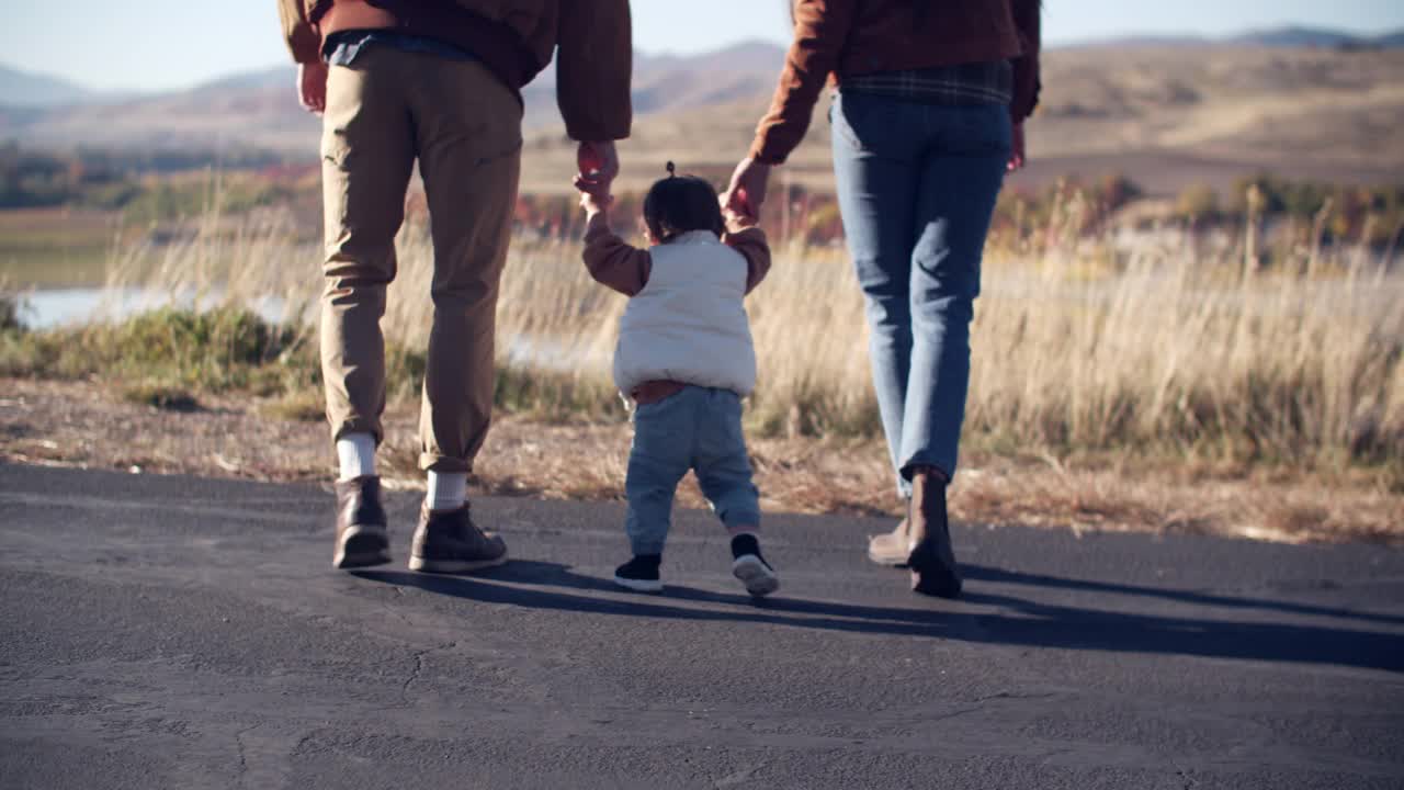 父母和蹒跚学步的孩子在乡下散步视频下载