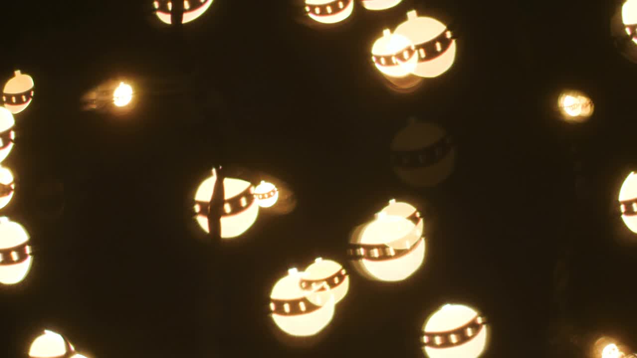 圣诞球形状的光覆盖在黑色背景视频下载