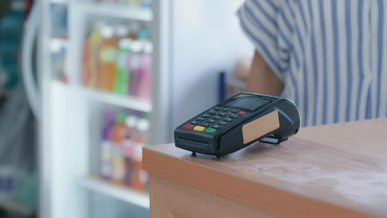 使用信用卡付款的客户。客户使用非接触式信用卡付款，柜台设有读卡机。通过NFC技术接受付款的收银员。视频下载