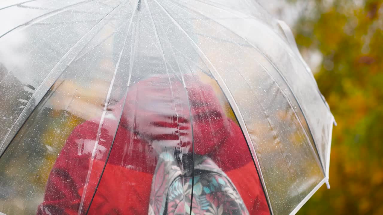 微笑的漂亮女人享受雨天。女孩站在伞下。秋天的心情，黄叶视频素材