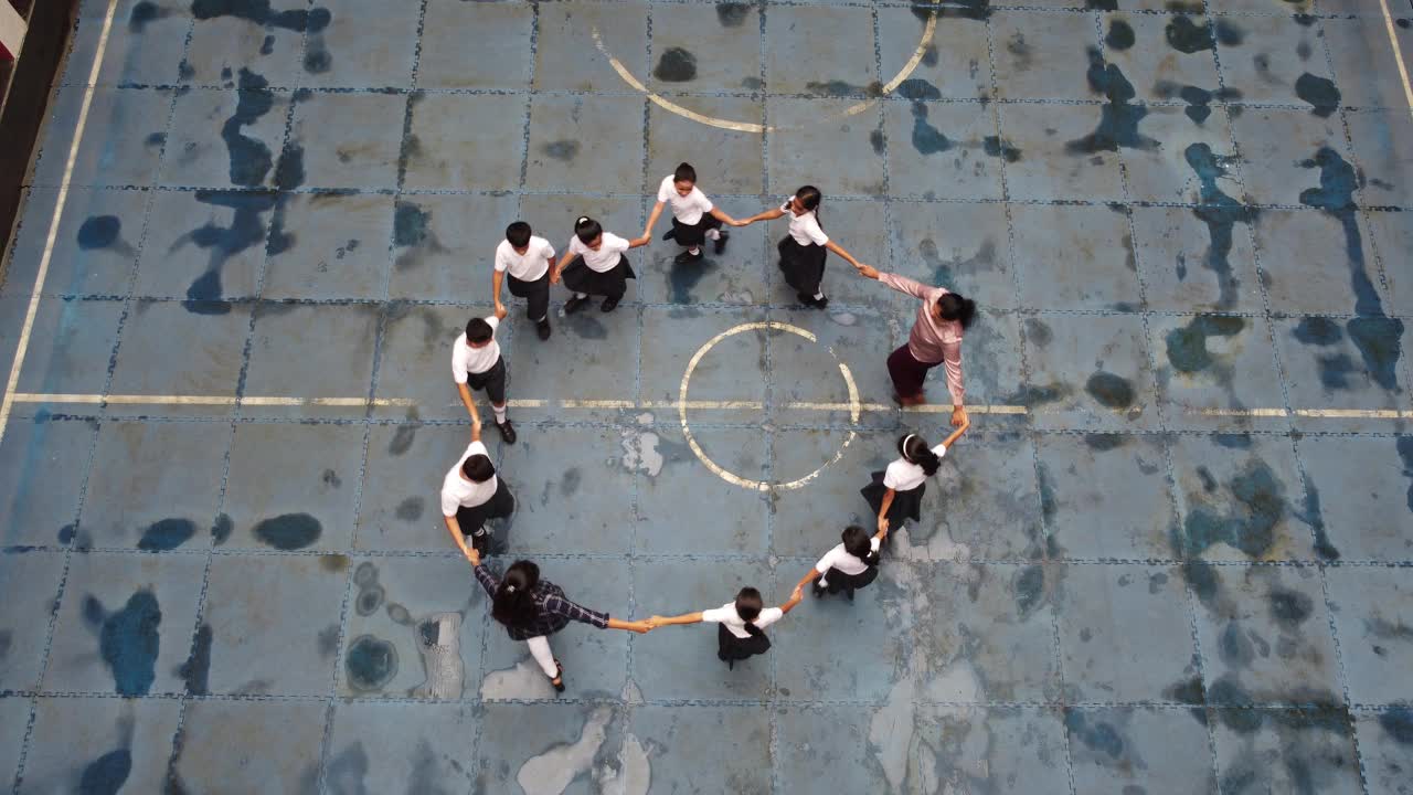 身穿校服的学生和手牵着手站成一个圆圈视频下载