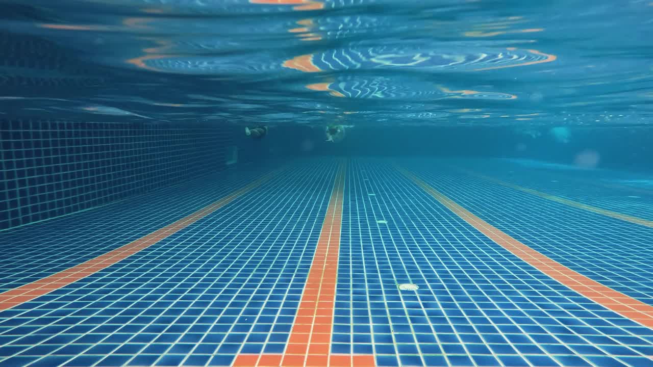 4k水下拍摄亚洲人在游泳池游泳。视频素材
