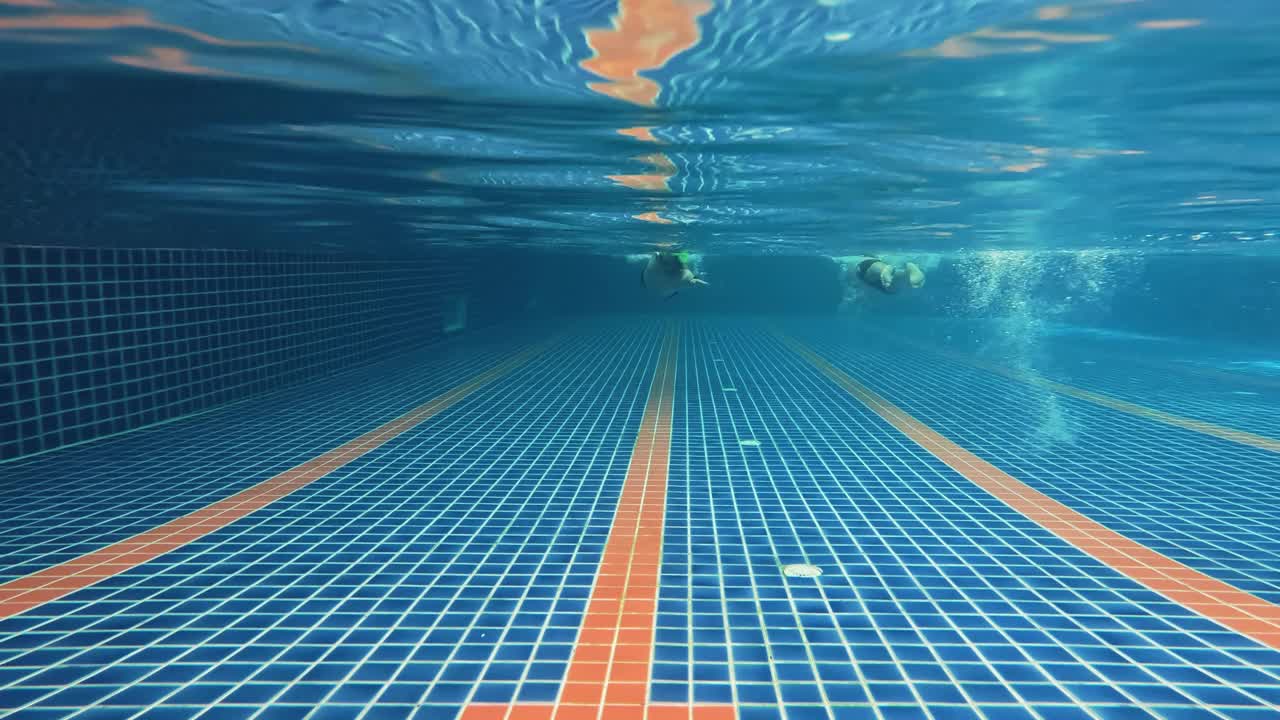 4k水下拍摄亚洲人在游泳池游泳。视频素材