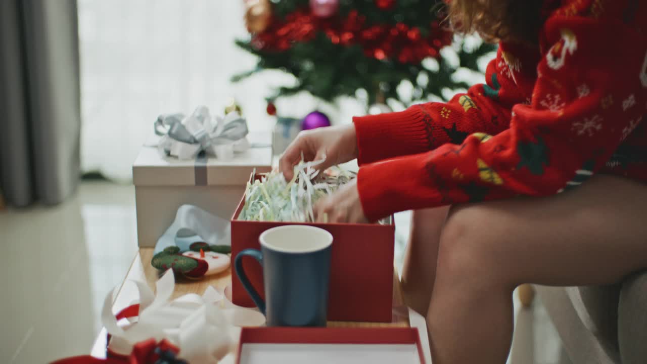 一名年轻女子正在包装圣诞节的礼品盒视频素材