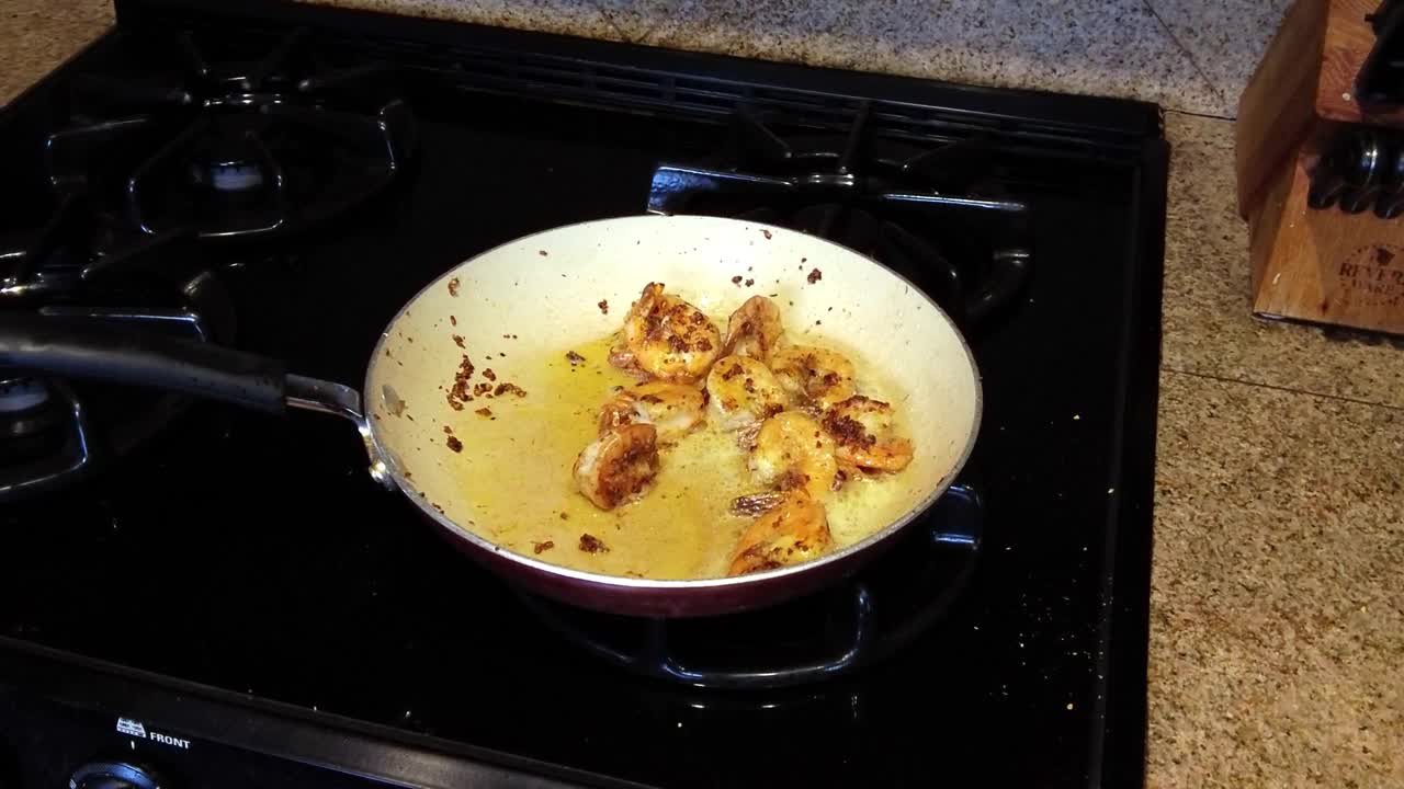 用平底锅煮鲜虾，加入香料和黄油，放在炉子上咝咝作响视频素材