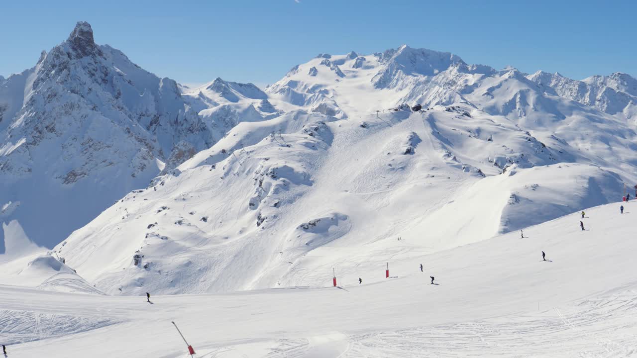 许多滑雪者和单板滑雪者开始从山顶滑下斜坡视频素材