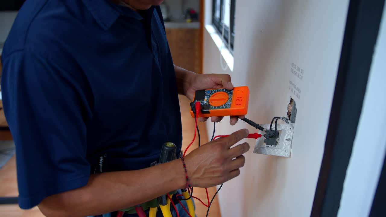 一个电工修理电源插座和测量电压在一个房子的特写视频素材