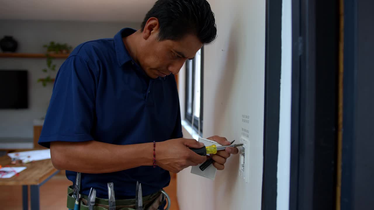 拉丁美洲的电工在家里修理插座视频素材
