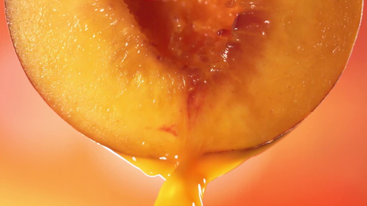 从半桃子流出的桃子汁的慢动作微距镜头视频素材
